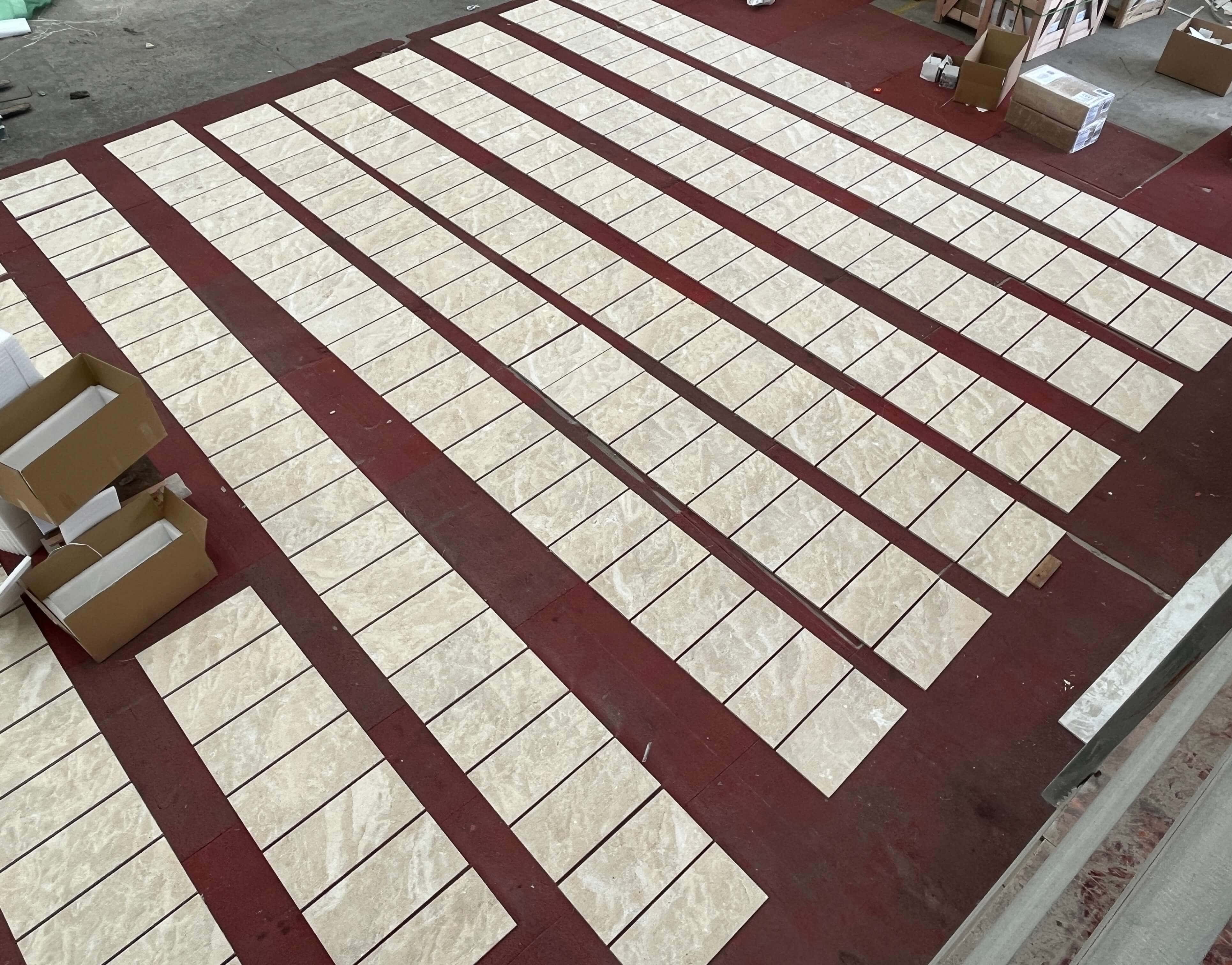 High angle factory view of Amber Gold fluted marble wall tiles laid out for thorough quality control before box packaging.