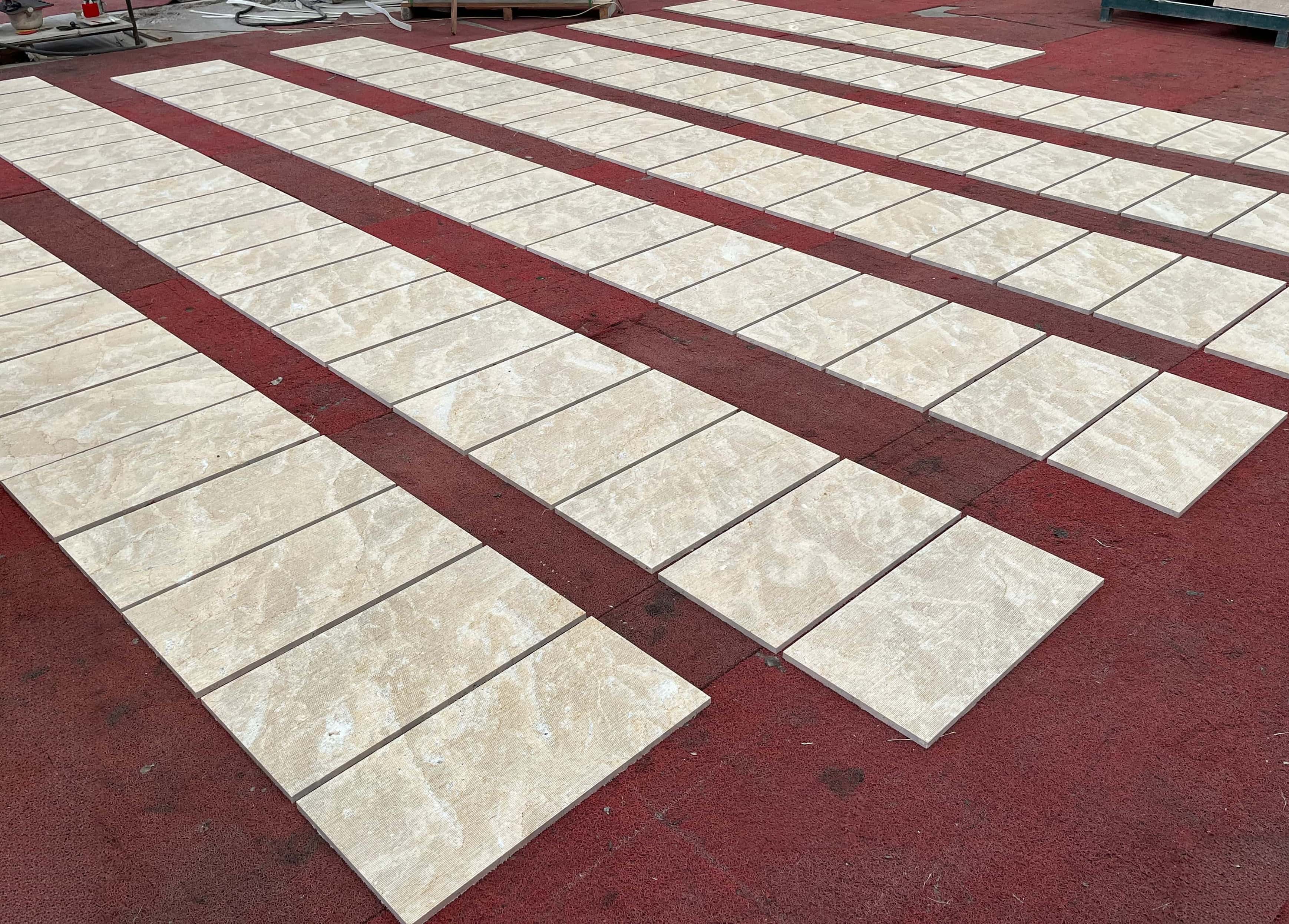 Perspective view of Amber Gold textured marble wall tiles neatly laid out for tonal matching and surface finish inspection.