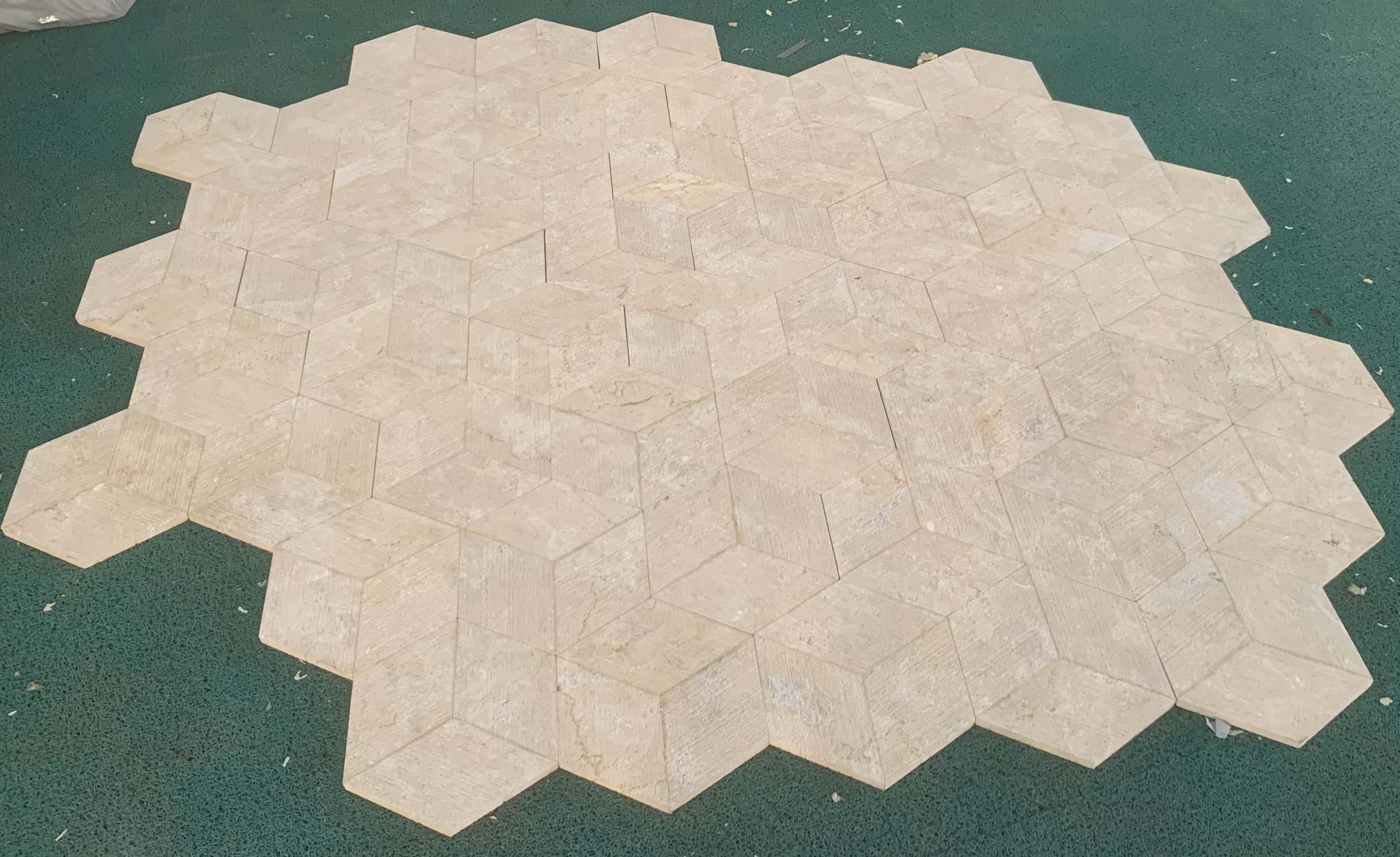 Flat dry-lay assembly of Amber Gold natural marble hexagon tiles demonstrating seamless edge-to-edge pattern alignment.