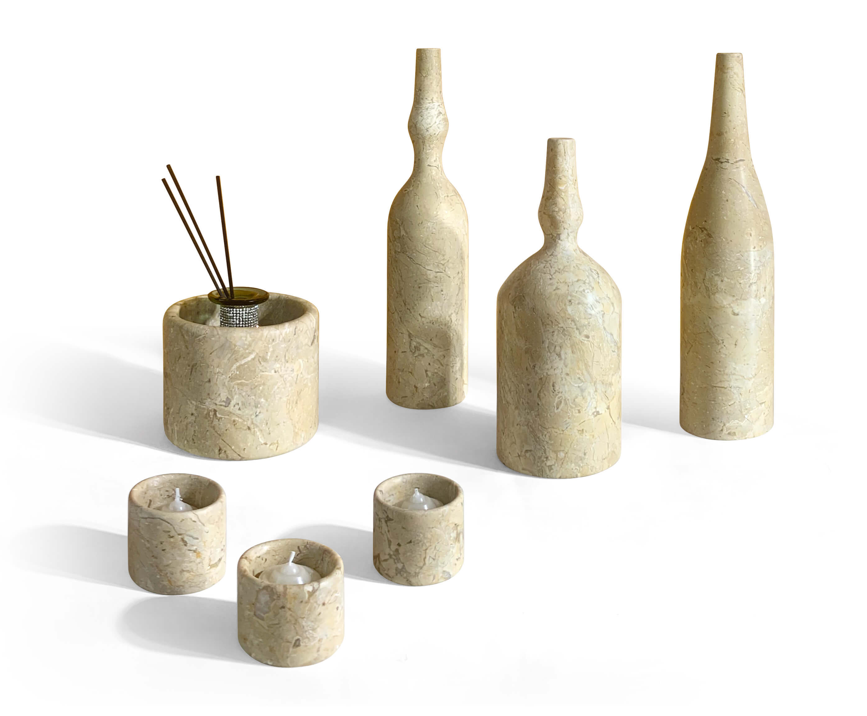 Styled seven-piece Amber Gold natural marble decor set displayed with diffuser reeds and burning tealight candles.