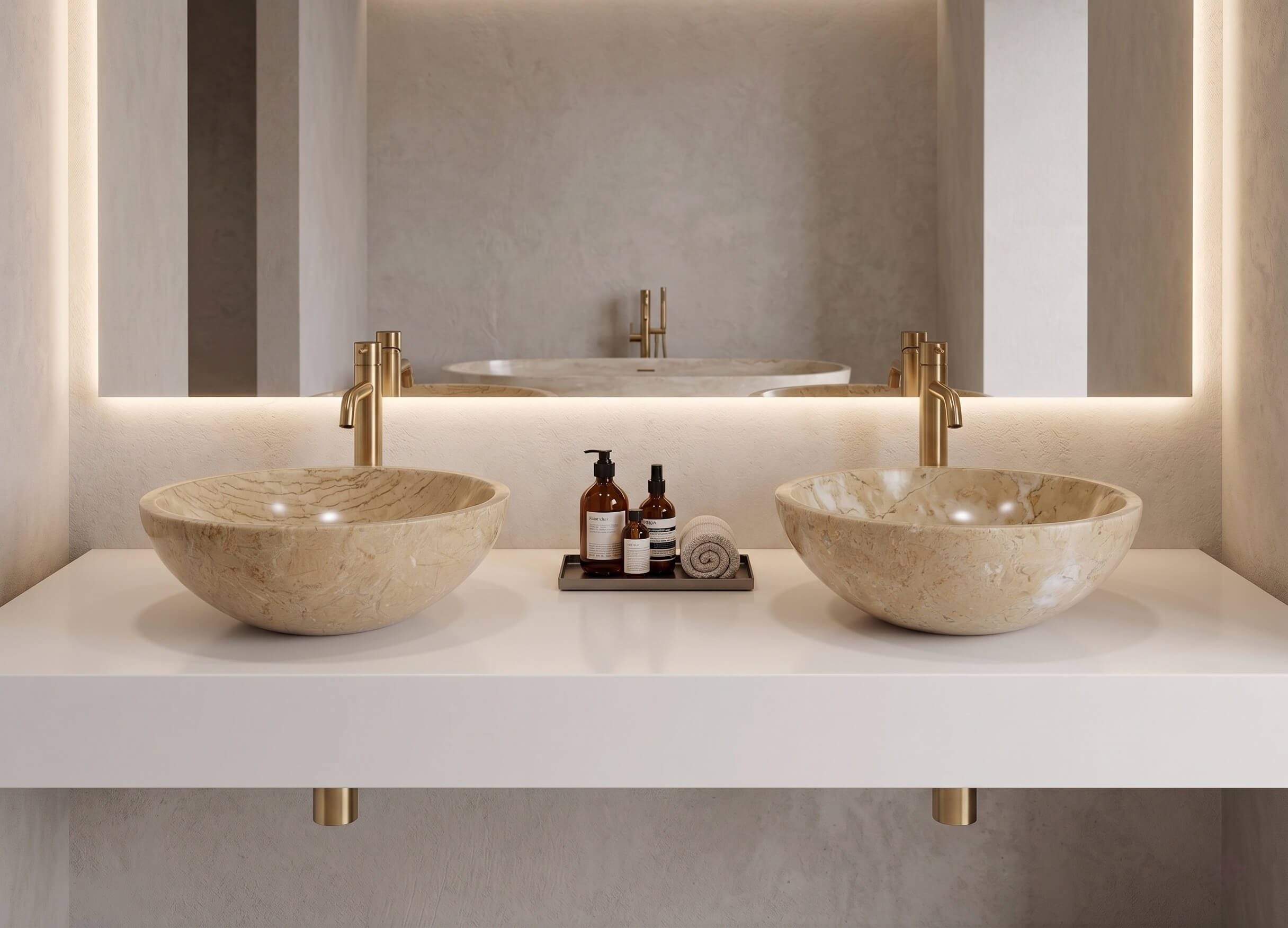 Two Amber Gold marble vessel sinks on white floating counter with brass faucets and LED cove lighting, minimalist suite.