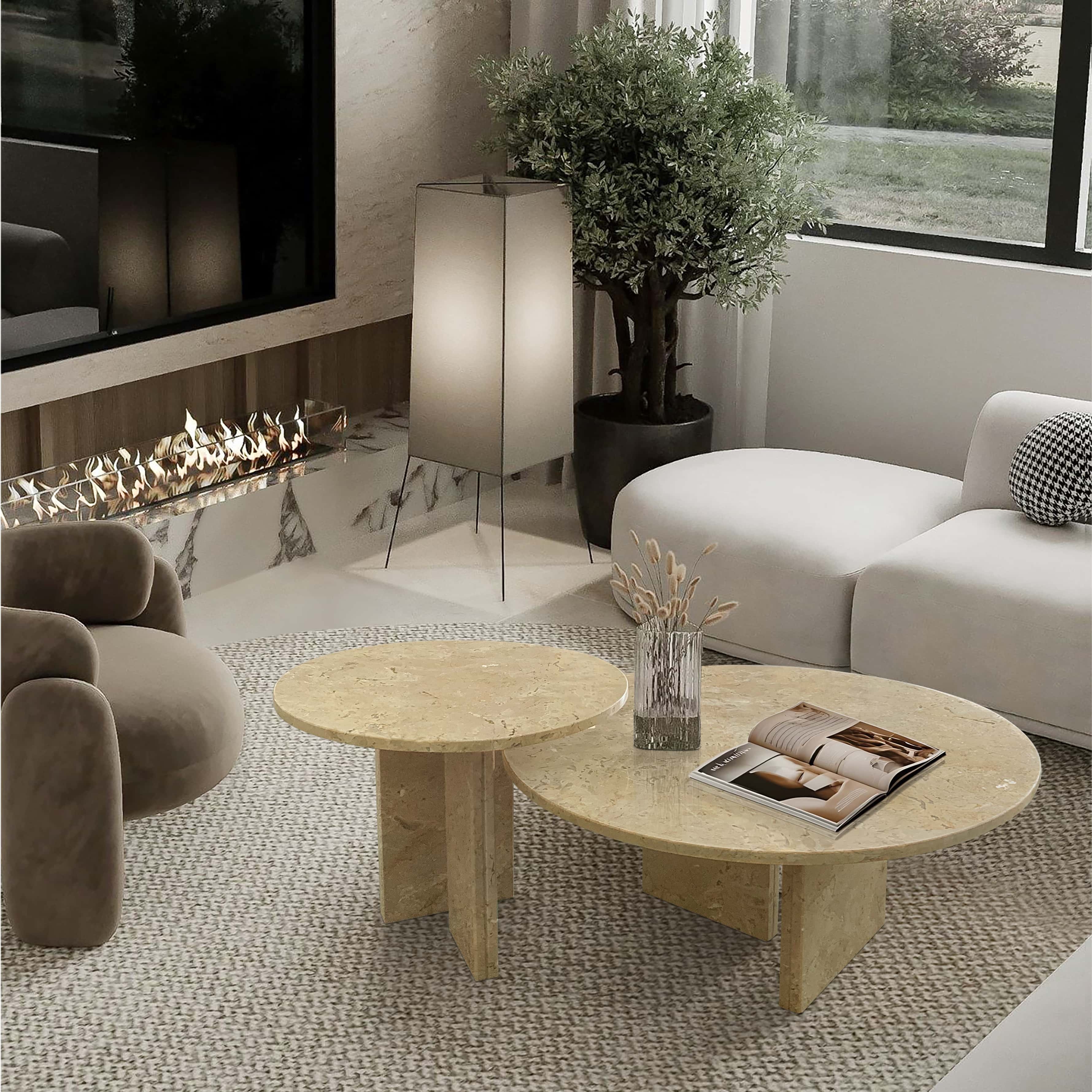Amber Gold marble nesting coffee tables displayed on a circular woven rug in a contemporary lounge with a fireplace.