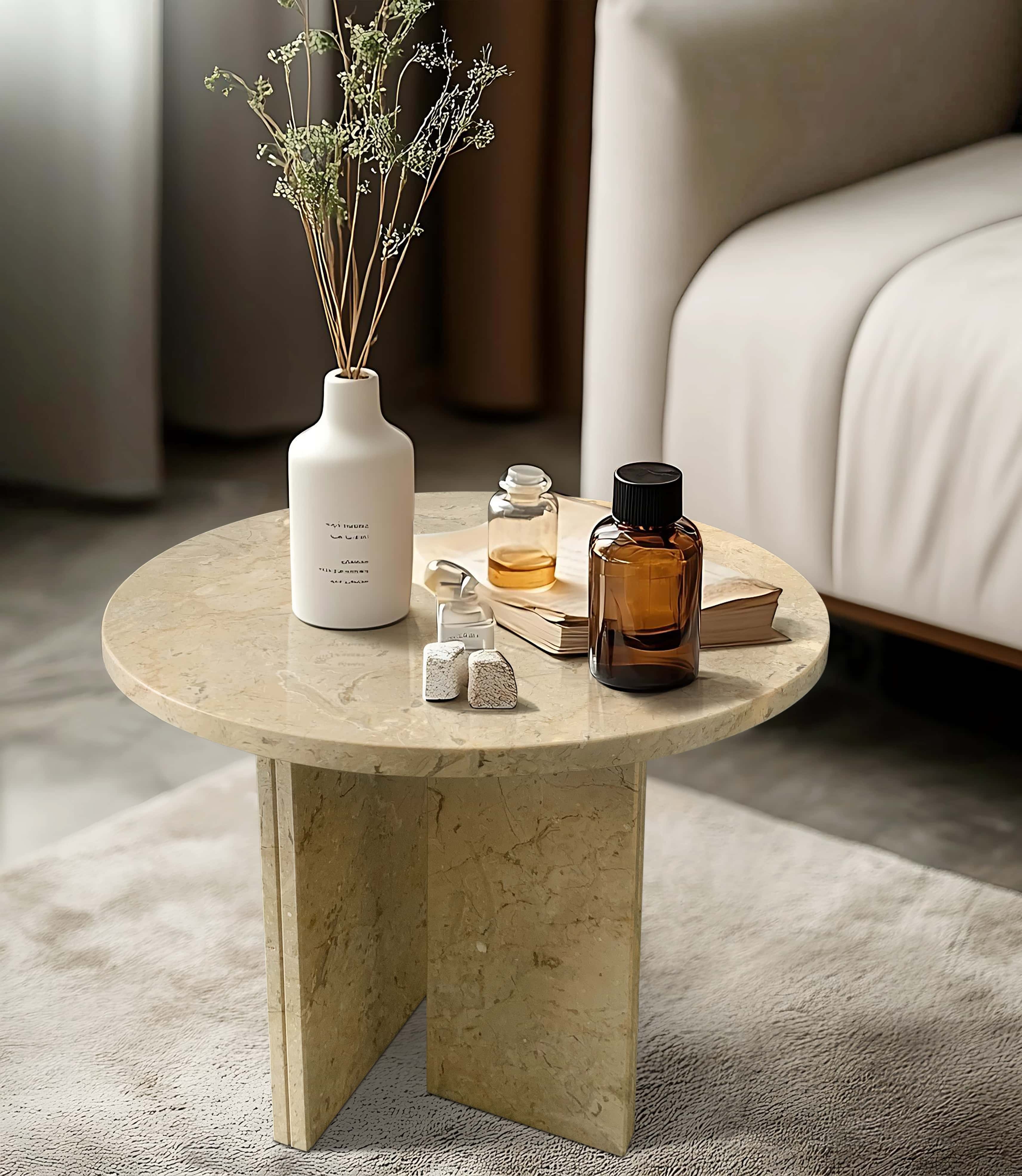 Angled view of a 45cm Amber Gold marble side table styled with books and glass decor in a modern living room.