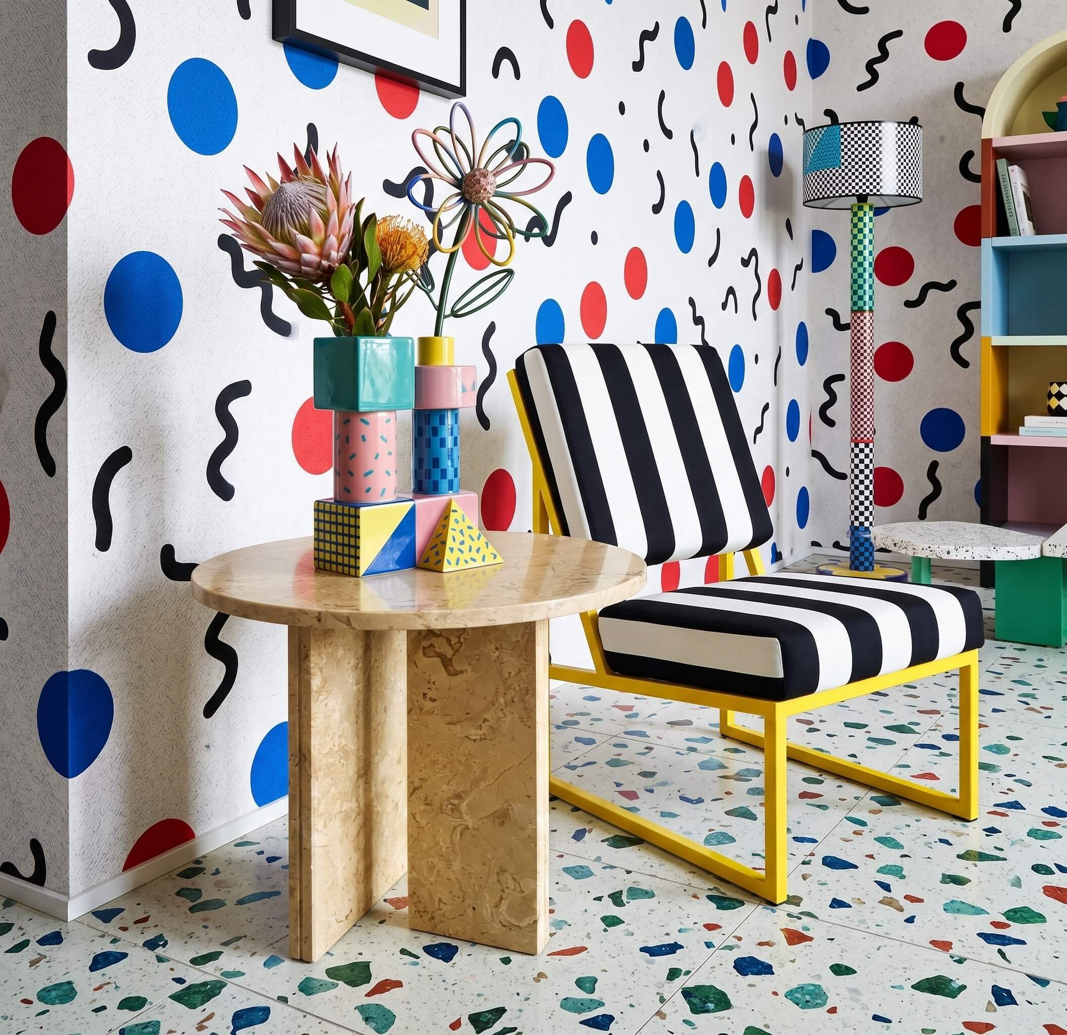 Amber Gold 45cm marble side table styled with geometric vases in a bold pop-art room with a striped chair.
