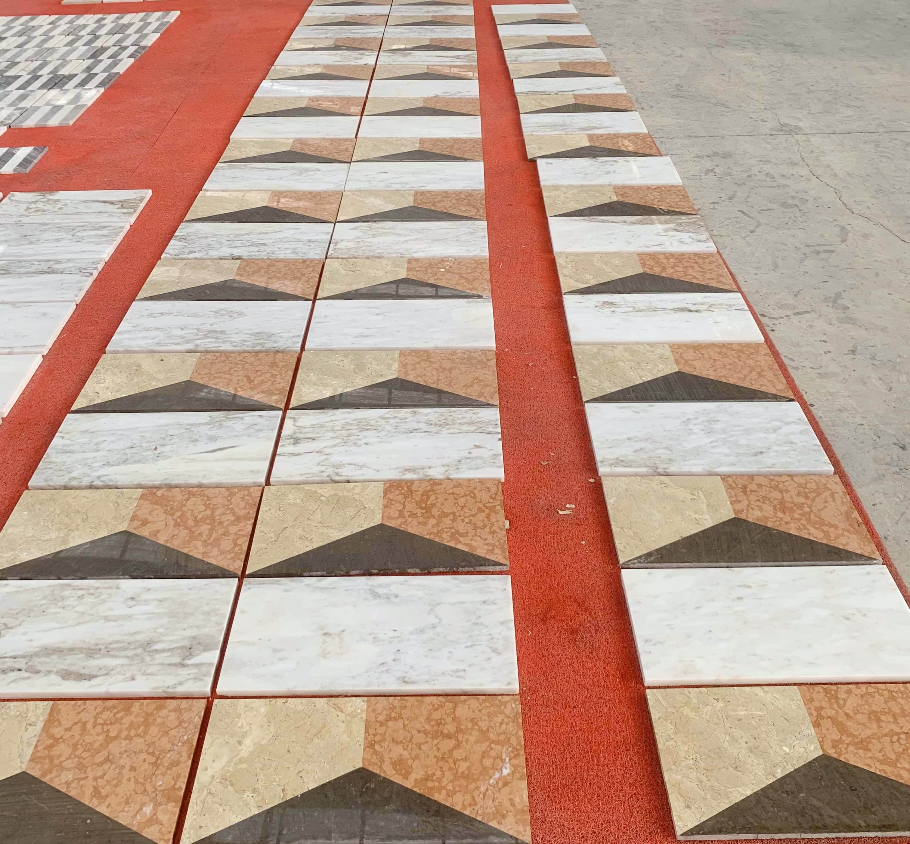 Close-up view of the polished four-color waterjet marble tiles during layout inspection, ready for quick US warehouse dispatch.