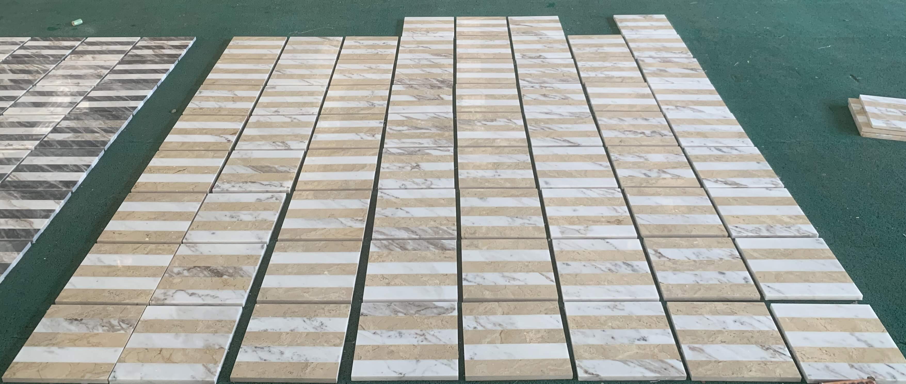 Batch production quality inspection displaying multiple rows of polished White and Gold waterjet marble tile sets.