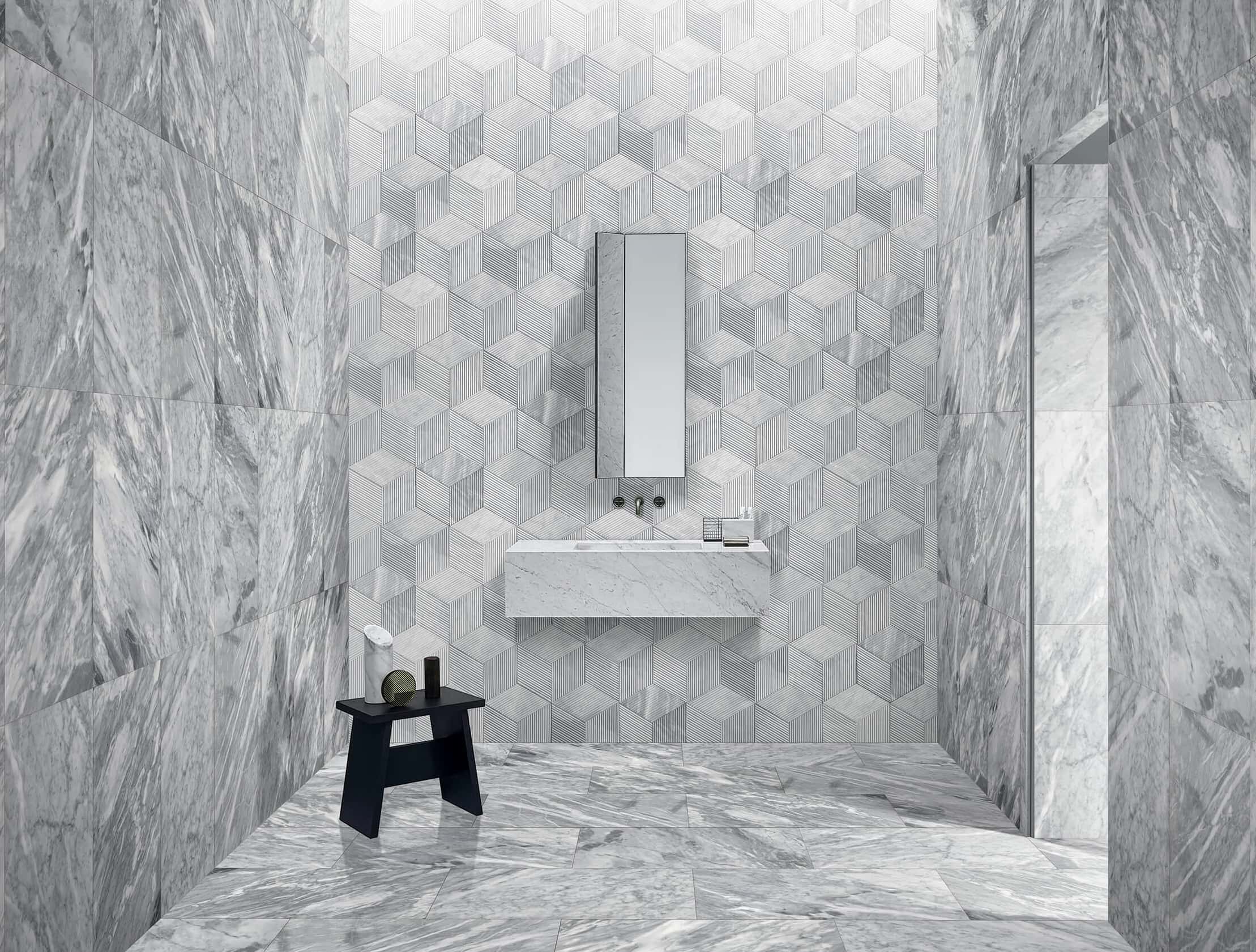 Sleek bathroom with floating sink, 12x24 Carrara Gray polished floor and side walls, and hexagon textured center wall.