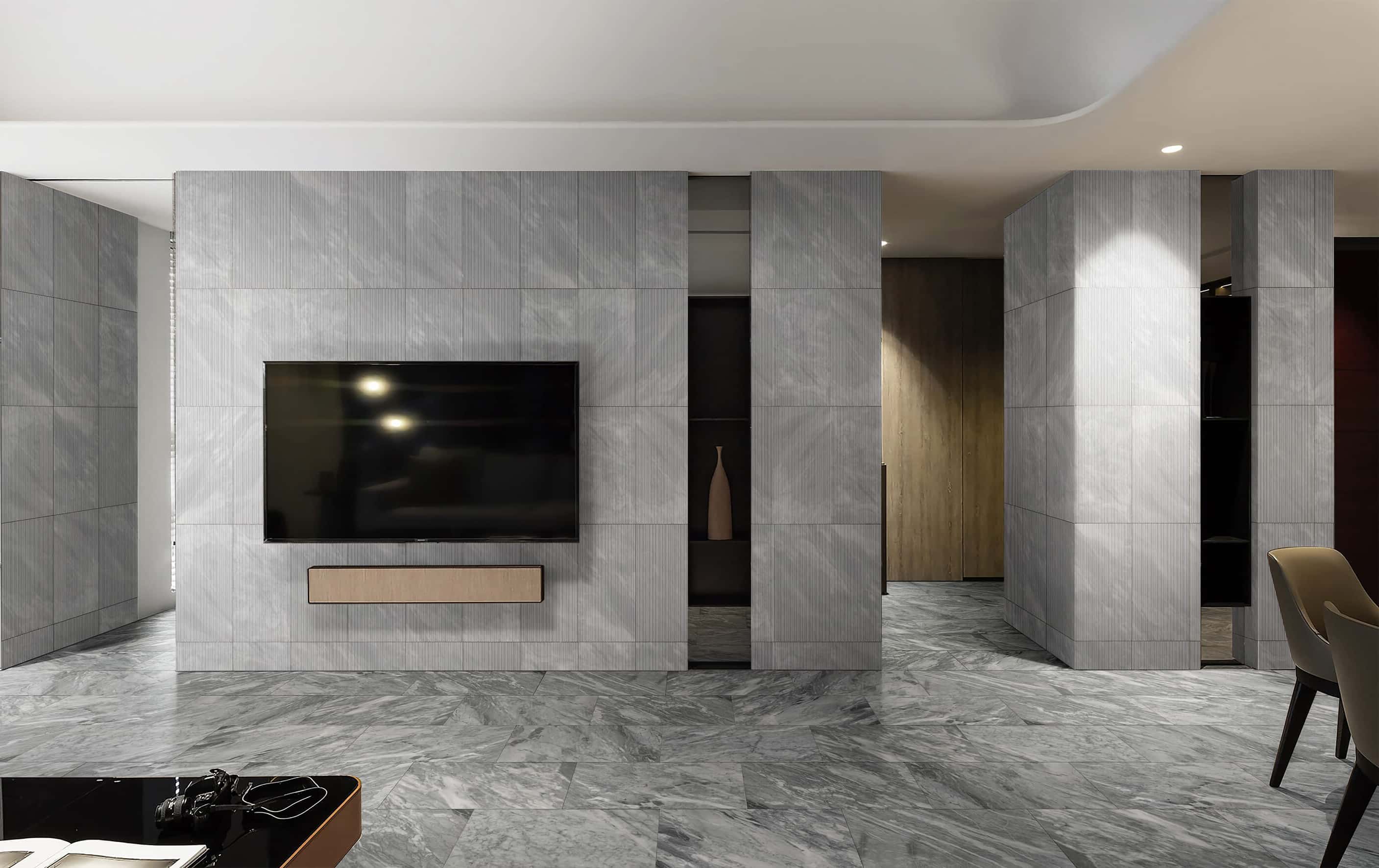 Living room TV feature wall with fluted marble tile accent wall and 12x24 Carrara Gray polished marble floor tiling.