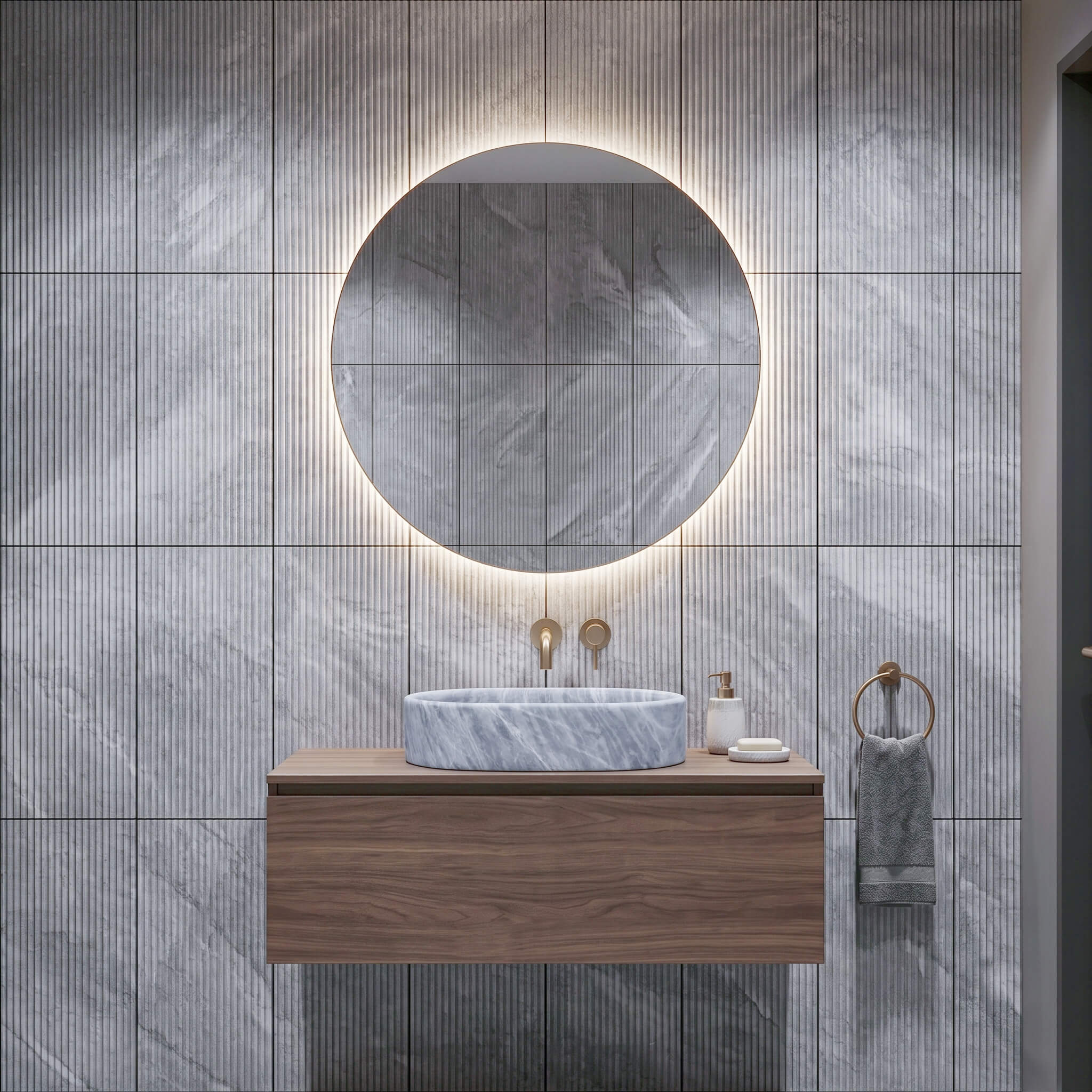 Wall-mounted walnut vanity with a Carrara gray honed oval vessel sink set against 12x24 fluted marble wall tiles.