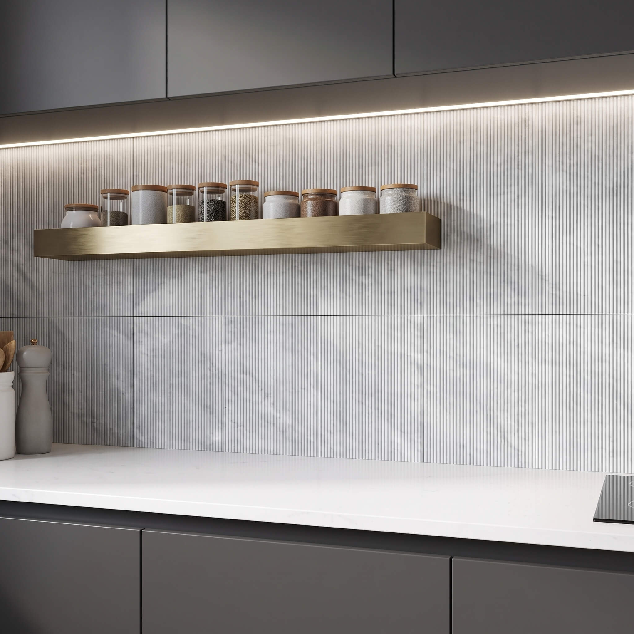 Under-cabinet lighting illuminating 12x24 fluted Carrara gray marble tiles on a modern kitchen backsplash wall.