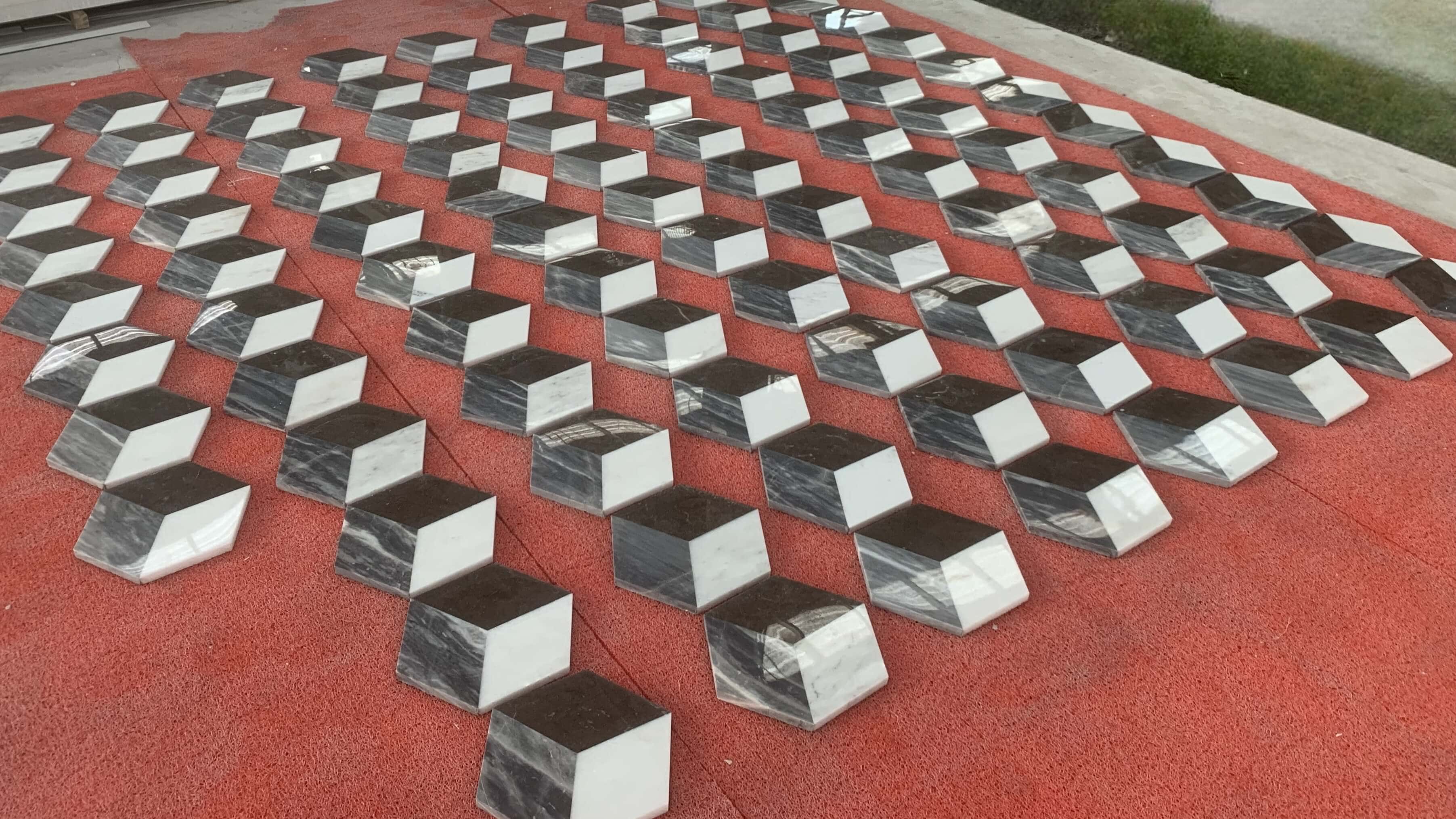 Bulk factory inventory showing 0.7 inch thick 3D cube illusion white, gray, and black natural marble tiles in rows.