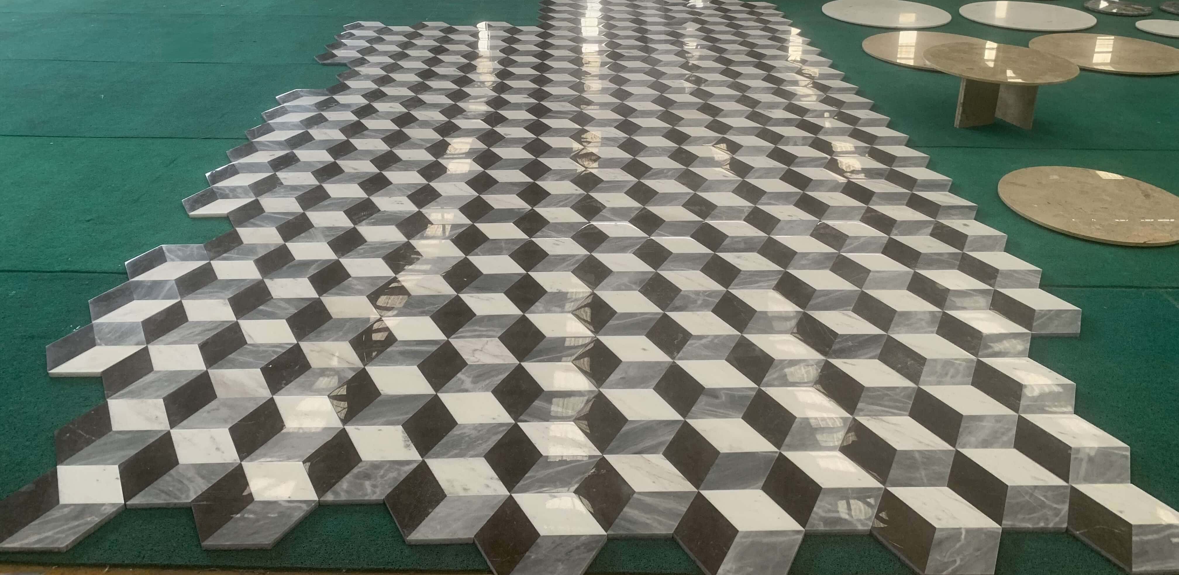 Polished finish dry lay floor layout displaying high surface gloss on white, gray, and black 3D waterjet marble tiles.