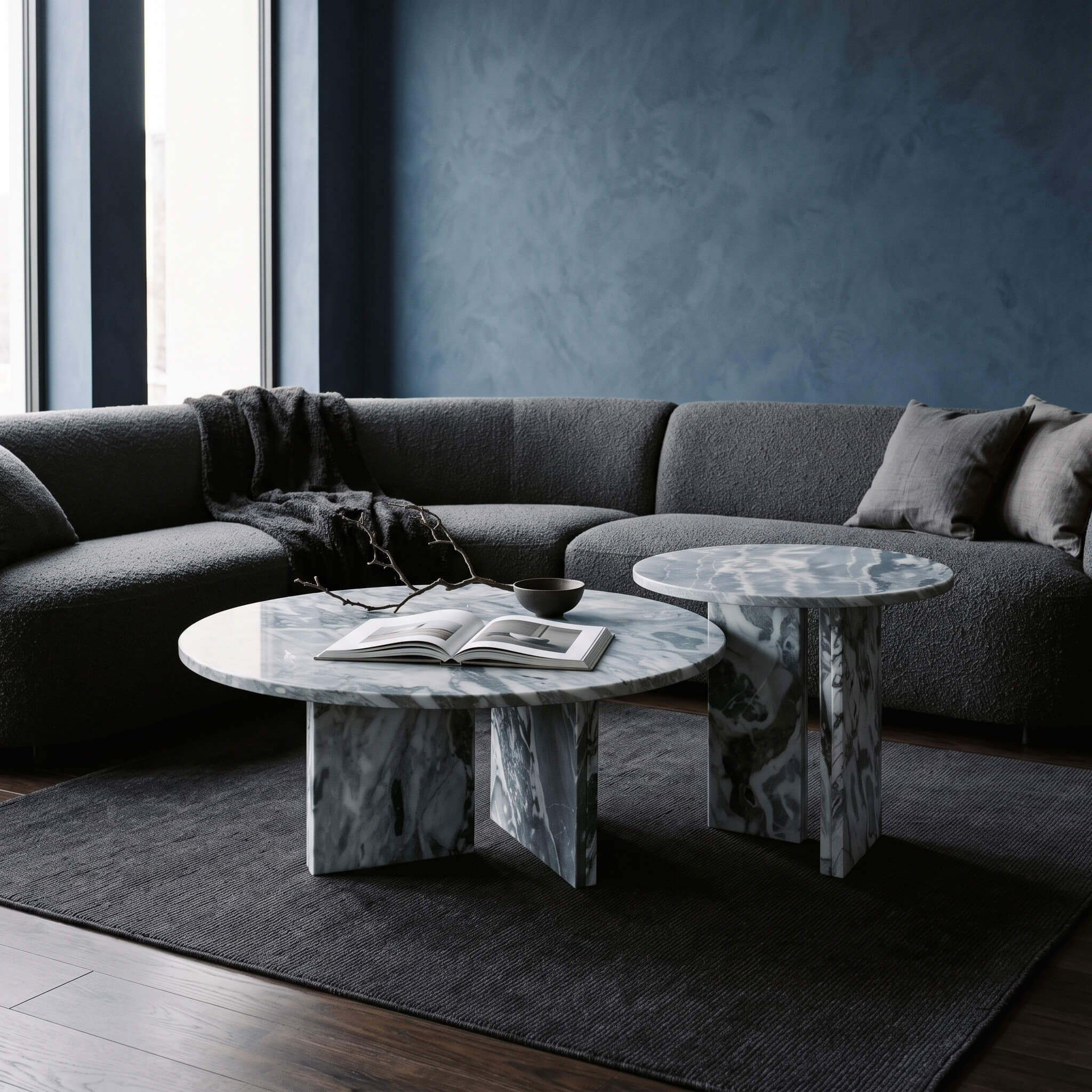 Two-piece round marble coffee table set featuring cloudy blue natural stone tops styled by a modern grey boucle curved sofa.