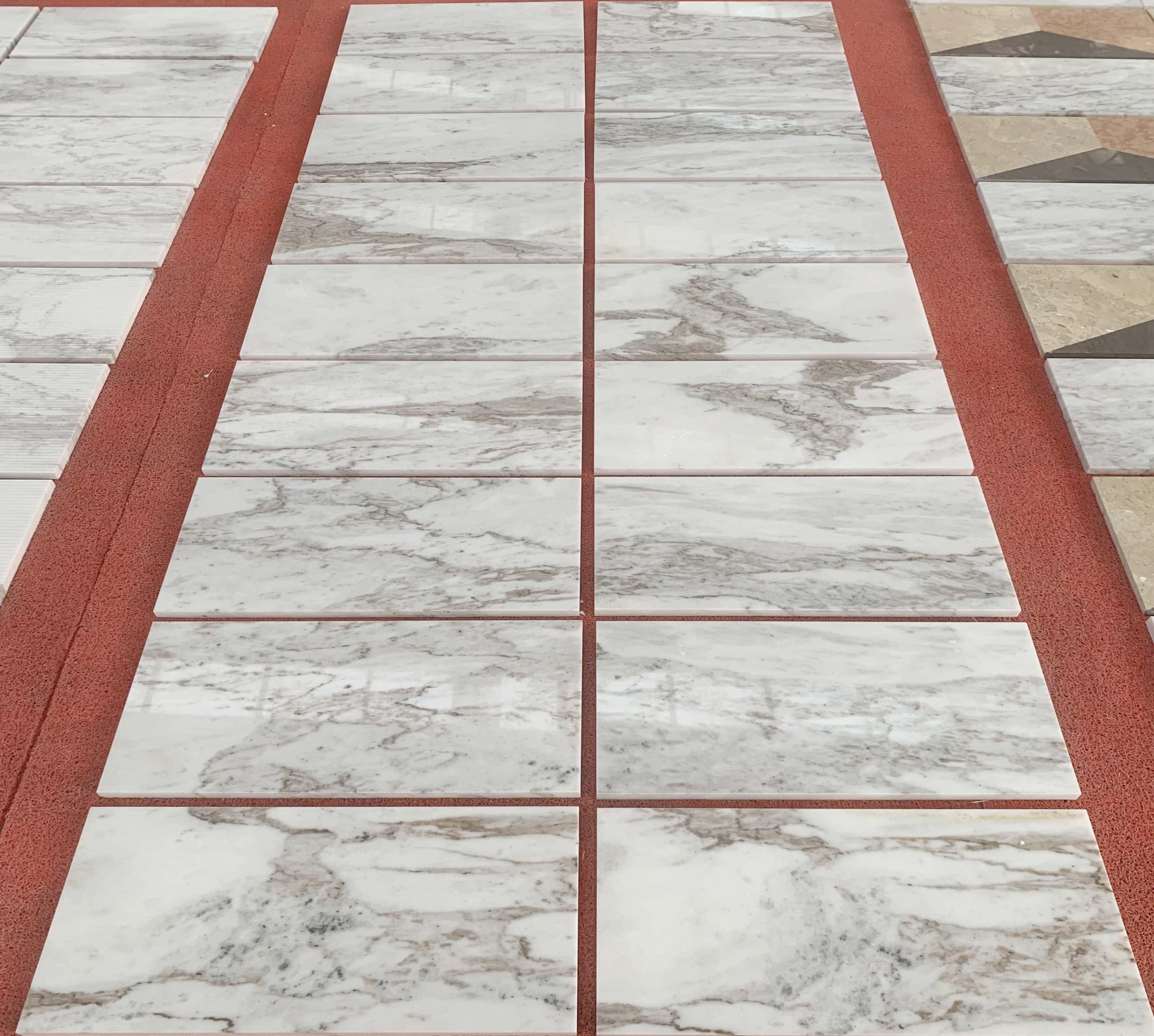 Bulk inventory of 12x24 Snow Mountain white stone tiles, displaying consistent quality and polished finish on the floor.