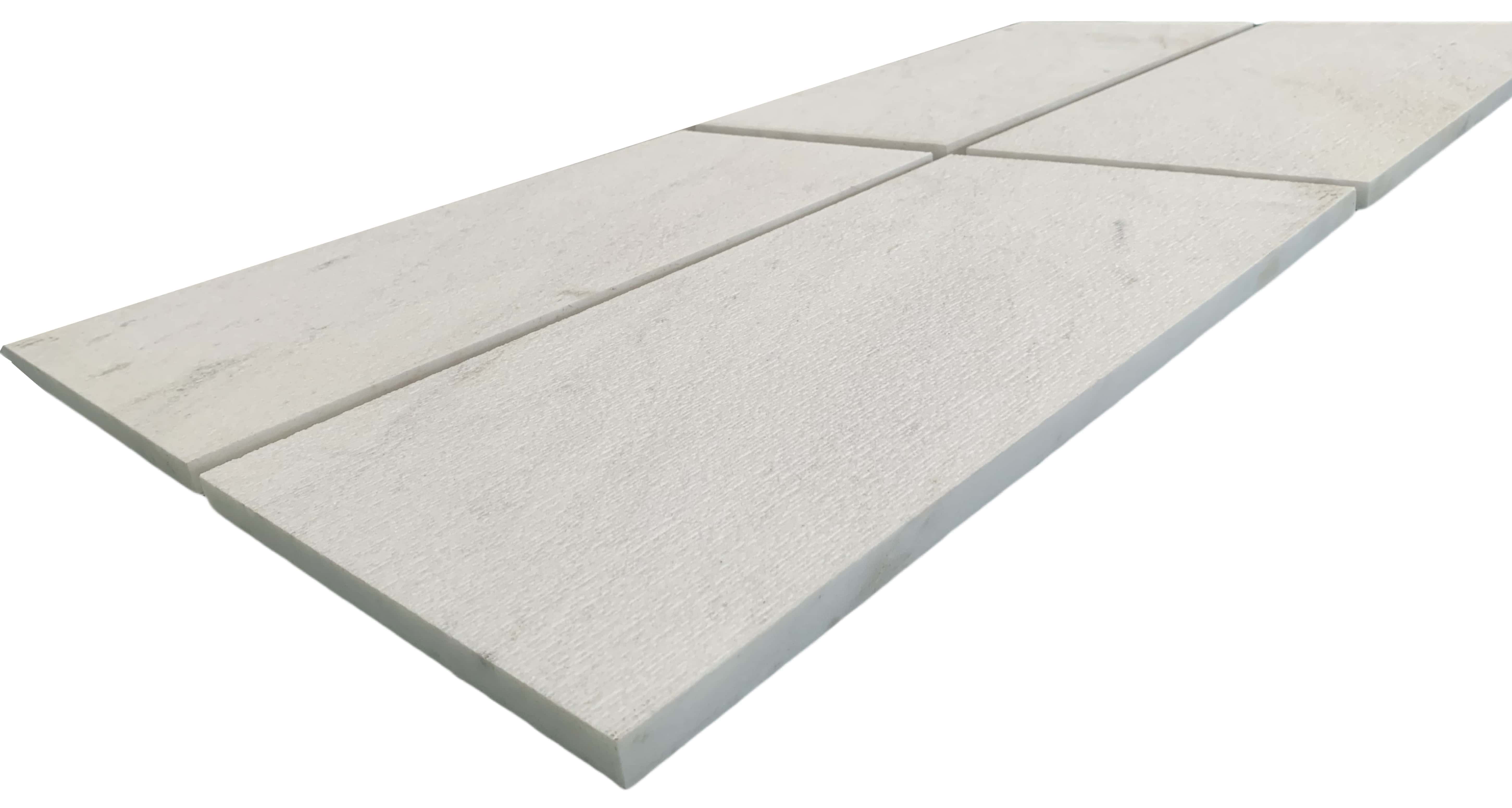 Angled close-up of four 12x24 Snow Mountain White FS textured marble tiles showing the 3D linear grooved fluted depth.