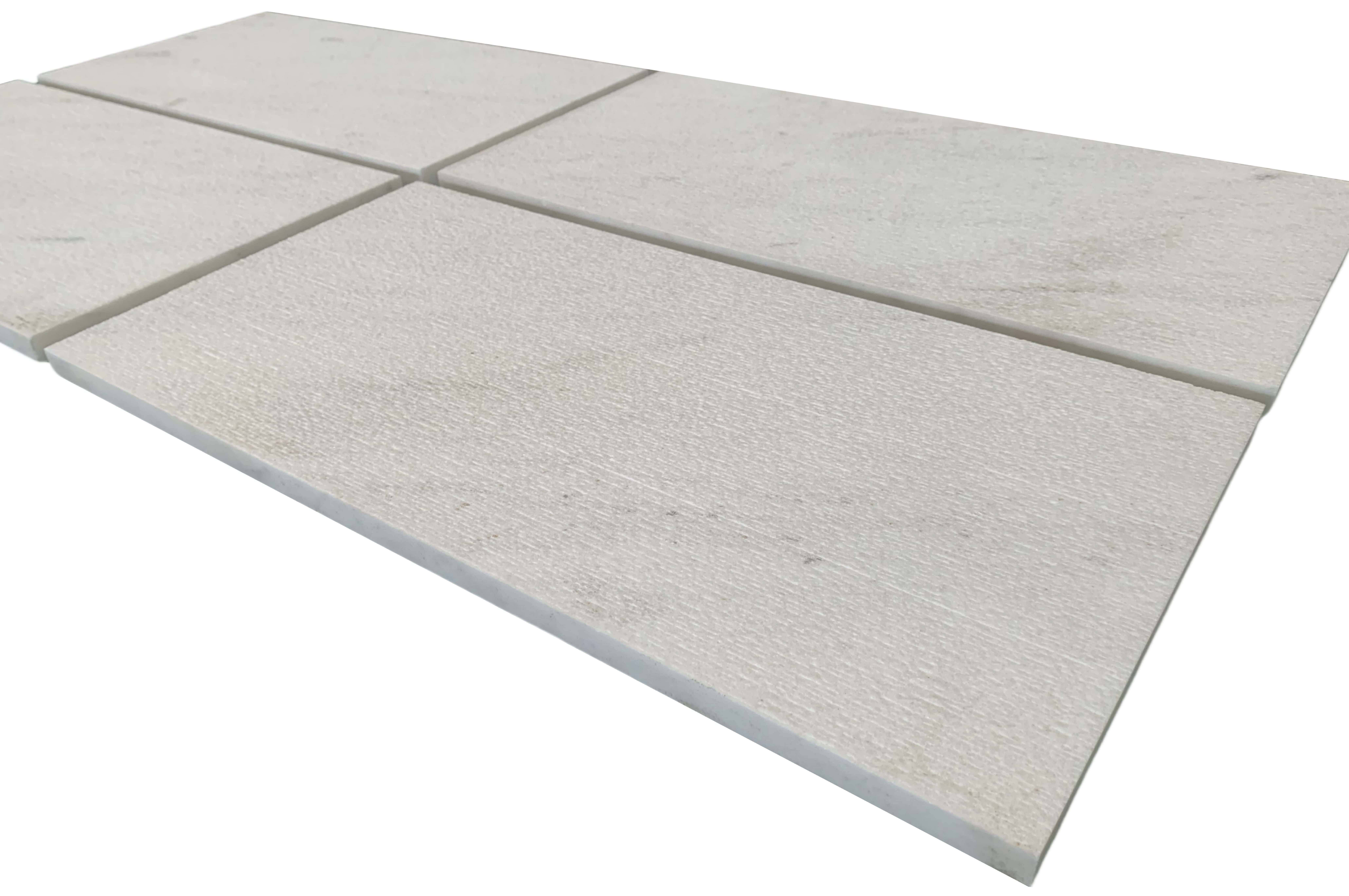 Surface detail of 12x24 Snow Mountain White FS textured marble tiles, highlighting the architectural grooved stone finish.