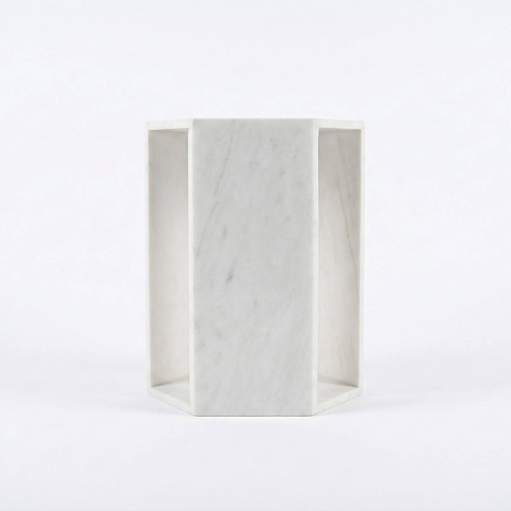 Side profile of the natural Snow Mountain White marble hexagon end table, displaying smooth honed finish and sturdy base.