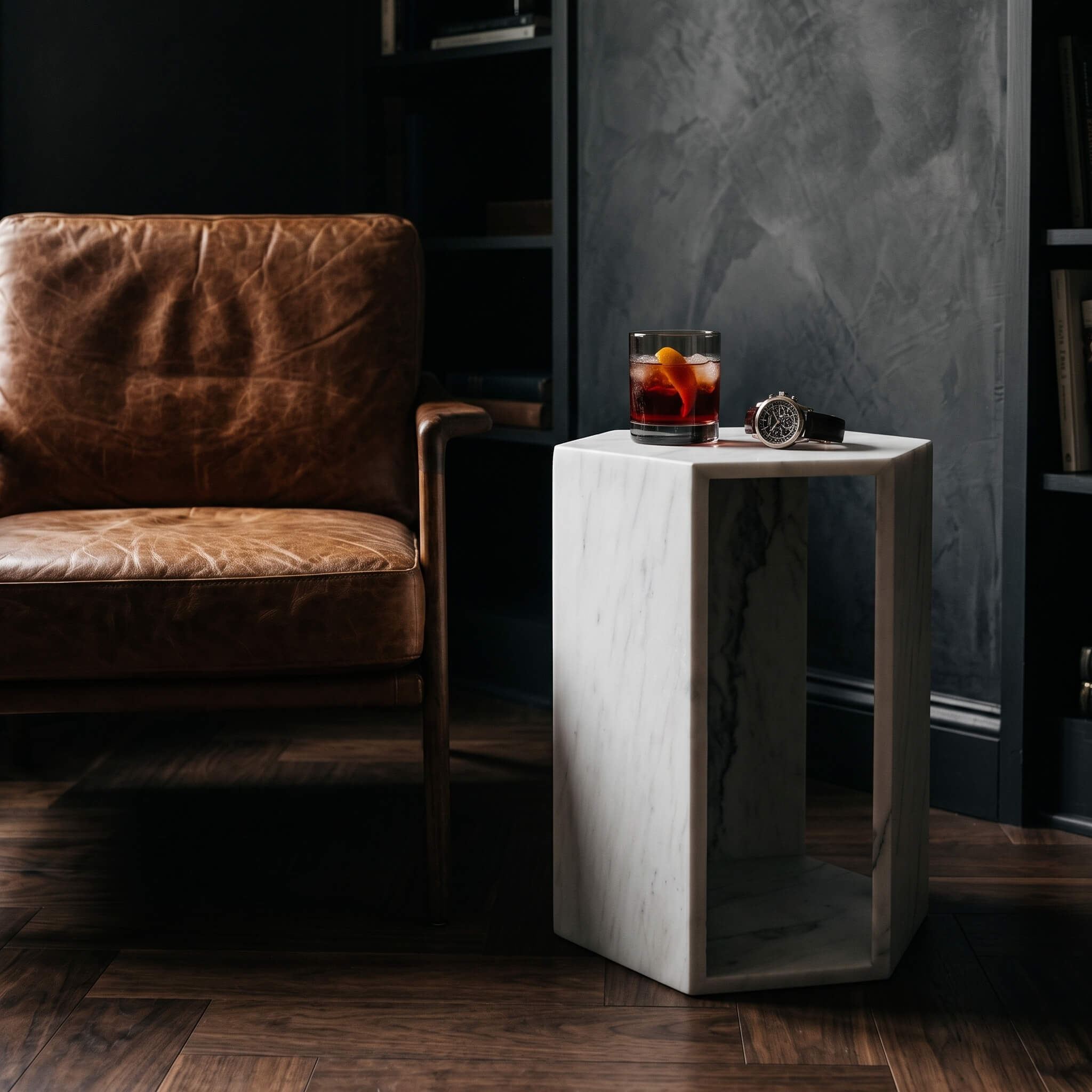 Snow Mountain White marble hexagon side table holding a whiskey glass and watch next to a leather chair in a dark study.