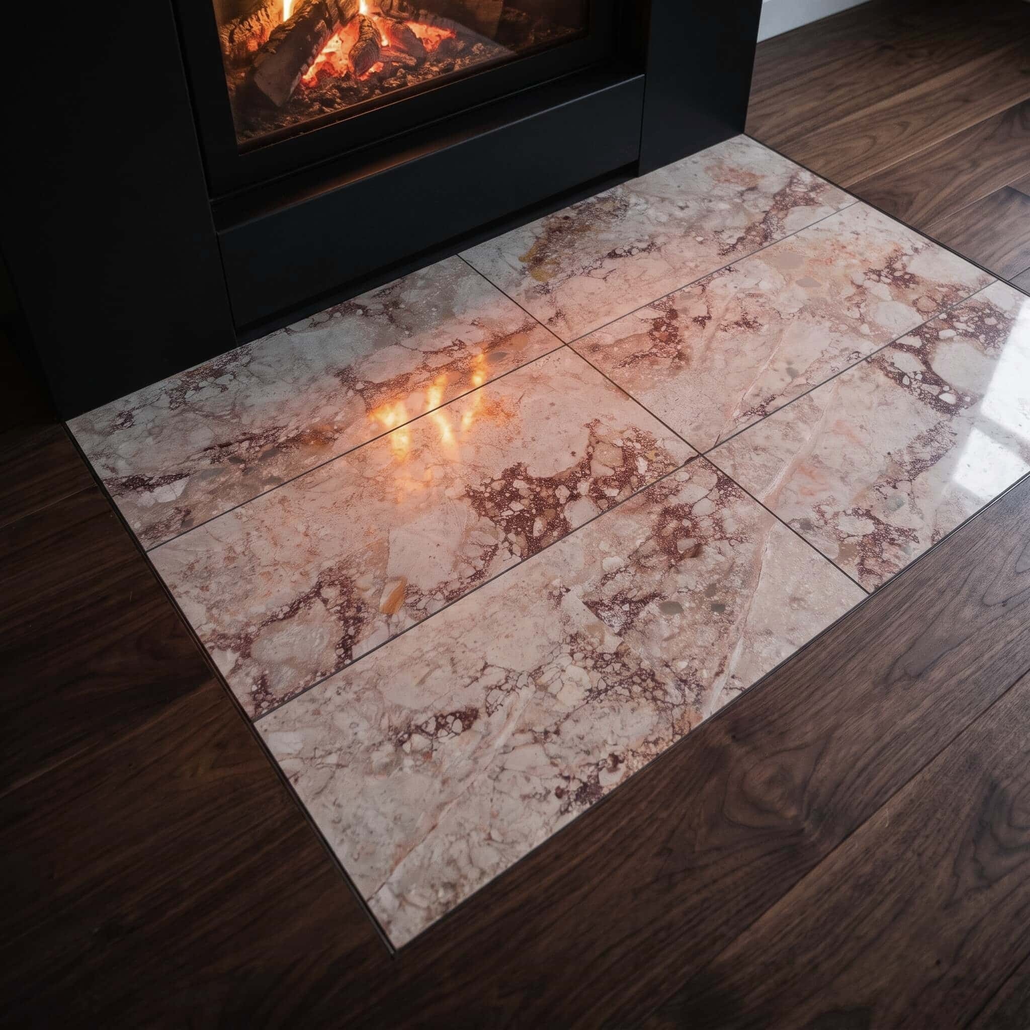 Flush-mounted 12x24 Diamond Pink marble tile for fireplace hearth inlay set in dark walnut wood living room floors.