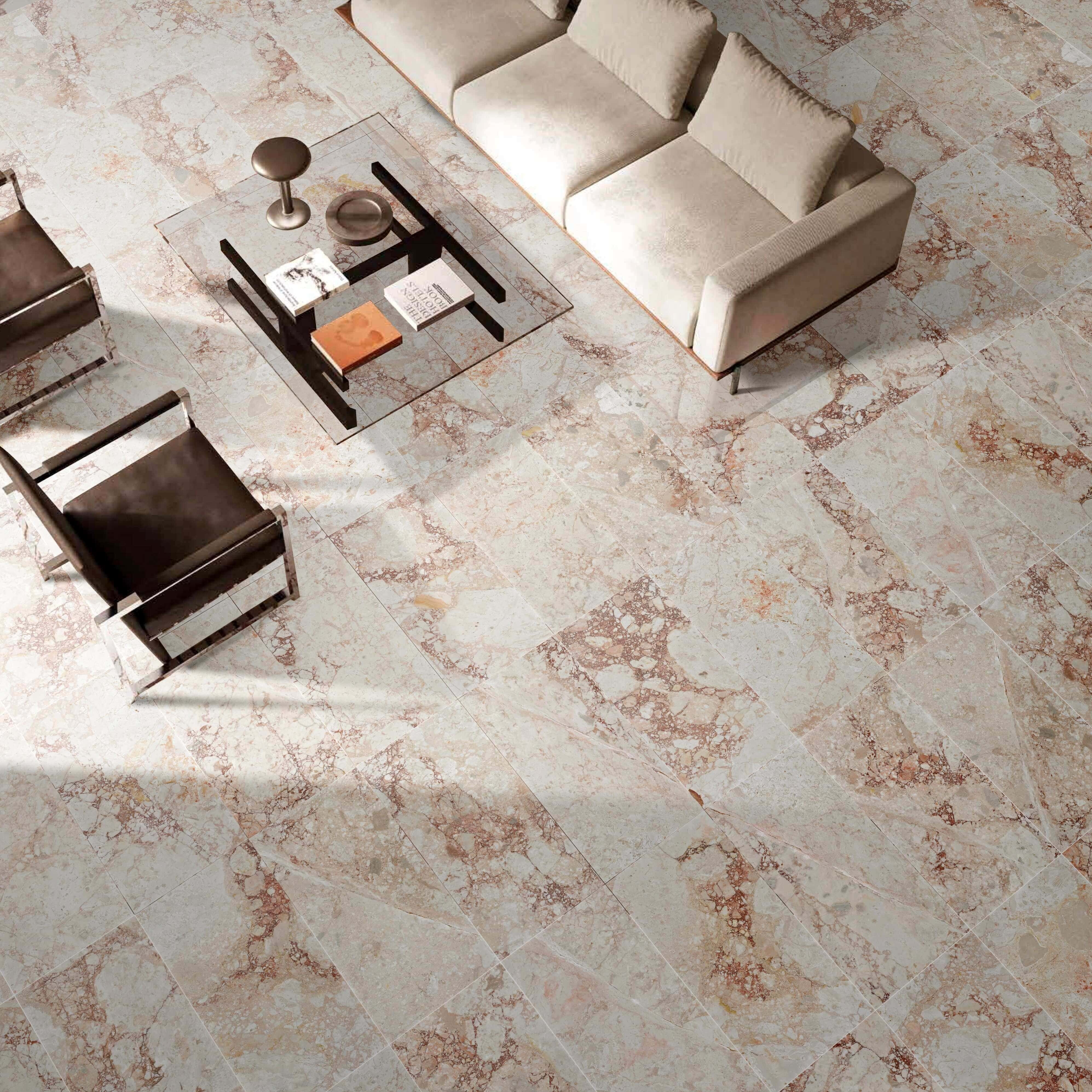 High-angle view of a 12x24 Diamond Pink marble living room floor with a cream sofa and glass coffee table seating.
