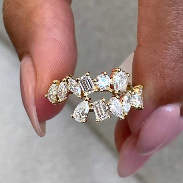 A detailed shot of a hand holding a mixed cut lab diamond ring, allowing a close inspection of the diamond clarity and gold polish texture.
