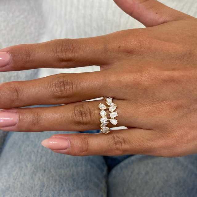 A hand wearing a 14k gold lab diamond ring captured in natural light, highlighting the brilliance of the E/F color stones and polished gold finish.