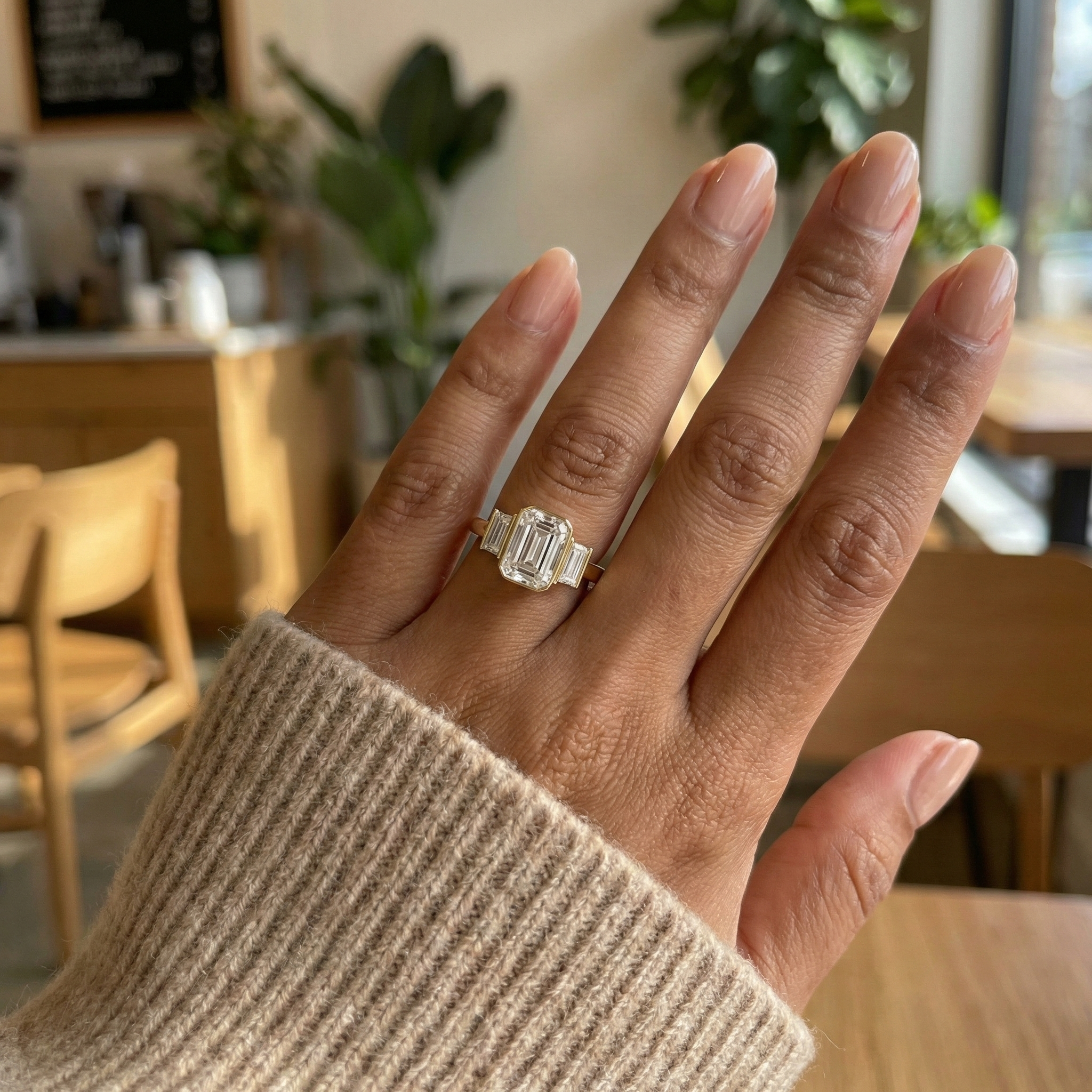 A 1.5ct emerald cut lab created diamond ring shown on a woman's size 6 hand, demonstrating the face-up size and finger coverage of the emerald cut stone with baguette accents.