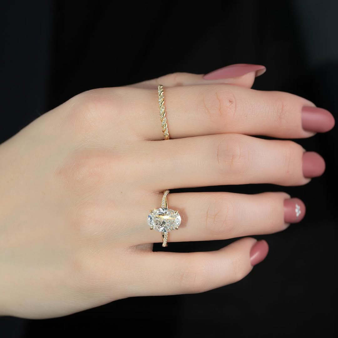 Woman wearing luxury 14K gold oval lab created diamond ring with twisted pavé setting