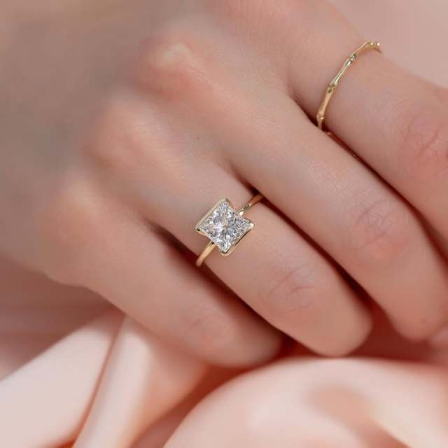 Top Down View of Minimalist Princess Cut Diamond Ring on Finger Modern Geometric Aesthetic