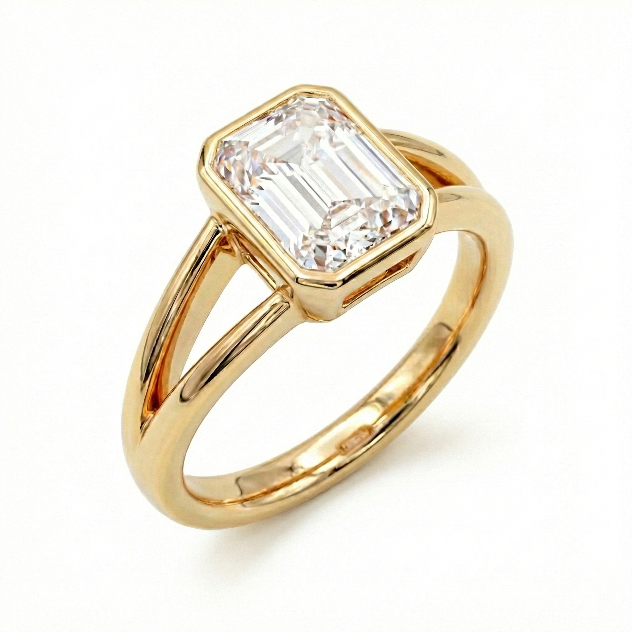 High-resolution view of an IGI certified 2 carat emerald cut lab diamond ring with a split shank and polished gold bezel.