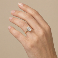 Hand modeling a large 4-carat step-cut emerald lab-grown diamond engagement ring, highlighting the pristine VS1 clarity and perfect proportions.