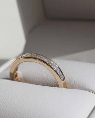 Macro photography of the 18K gold lab diamond ring resting inside a premium leather box, emphasizing the step-cut facets and pristine VS clarity of the stones.