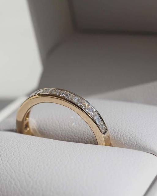 Macro photography of the 18K gold lab diamond ring resting inside a premium leather box, emphasizing the step-cut facets and pristine VS clarity of the stones.