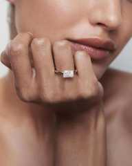 Female model wearing a custom 1.1 carat east-west radiant cut lab diamond engagement ring in 14K gold, emphasizing the extensive horizontal finger coverage and modern minimalist aesthetic of the design.