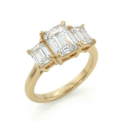 Angled close-up focusing on the architectural step-cut facets and secure 14K gold claw prongs of a 2.75 carat emerald cut lab-grown diamond.