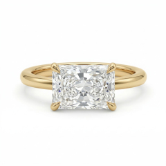 Studio isolation on a pure white background of a flawless-appearing D color, VVS2 clarity radiant cut lab grown diamond set horizontally in a highly polished 14K yellow gold east-west engagement ring band.