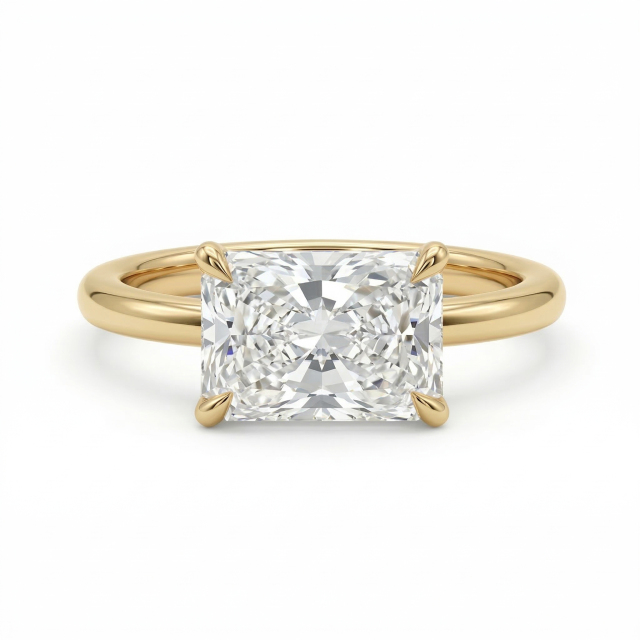 Studio isolation on a pure white background of a flawless-appearing D color, VVS2 clarity radiant cut lab grown diamond set horizontally in a highly polished 14K yellow gold east-west engagement ring band.