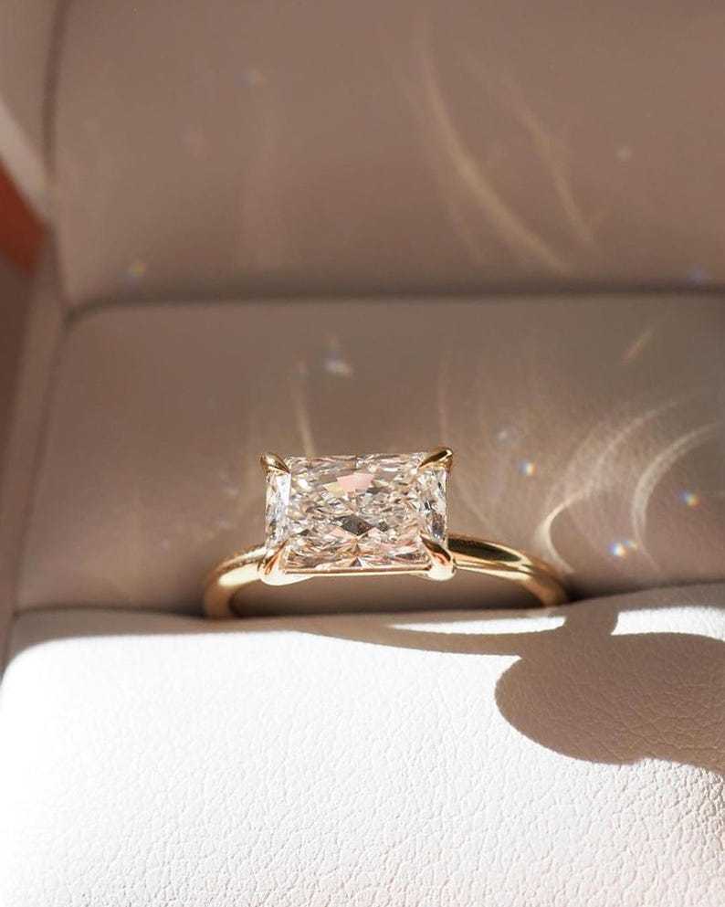 Extreme close-up of an IGI certified 1.1ct D VVS2 radiant cut lab created diamond displaying the highly desired 3EX crushed ice sparkle and intense rainbow fire within a customizable 14K gold east-west four-prong basket setting.