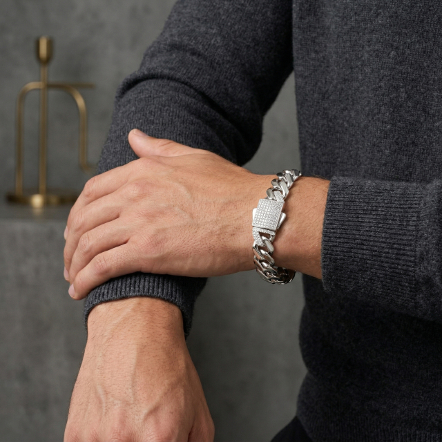 Man with crossed hands focusing on the wrist adorned with an Excellent cut, DE color top-tier moissanite Cuban link bracelet.