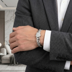 Man in a dark grey tailored suit wearing a brilliant moissanite S925 silver Cuban link bracelet, demonstrating luxury business-hip hop style.