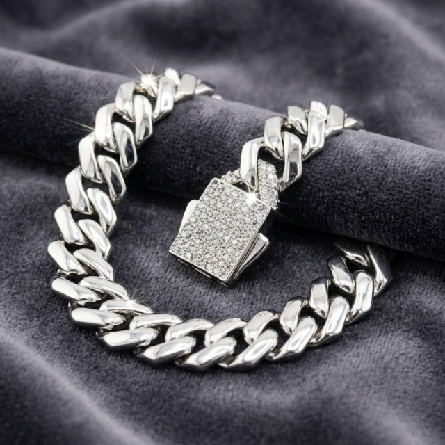 Iced-out Cuban link bracelet resting on grey velvet, highlighting the brilliant moissanite stones and the secure box clasp mechanism.