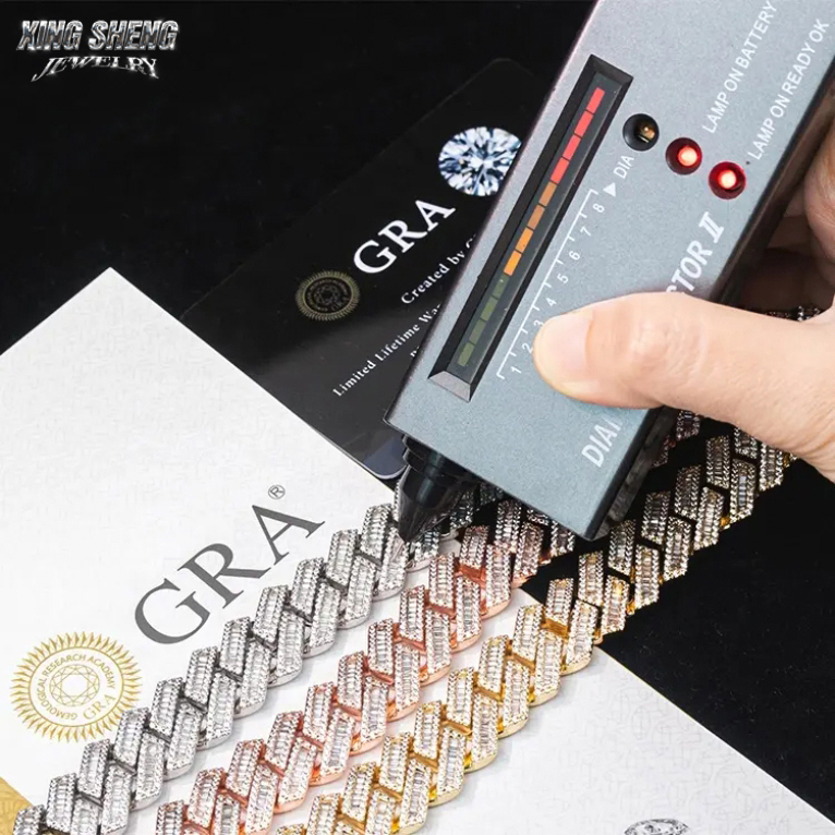 Handheld thermal diamond tester demonstrating a positive pass result on the 15mm baguette moissanite Cuban link chain, proving gemstone authenticity and premium thermal conductivity.