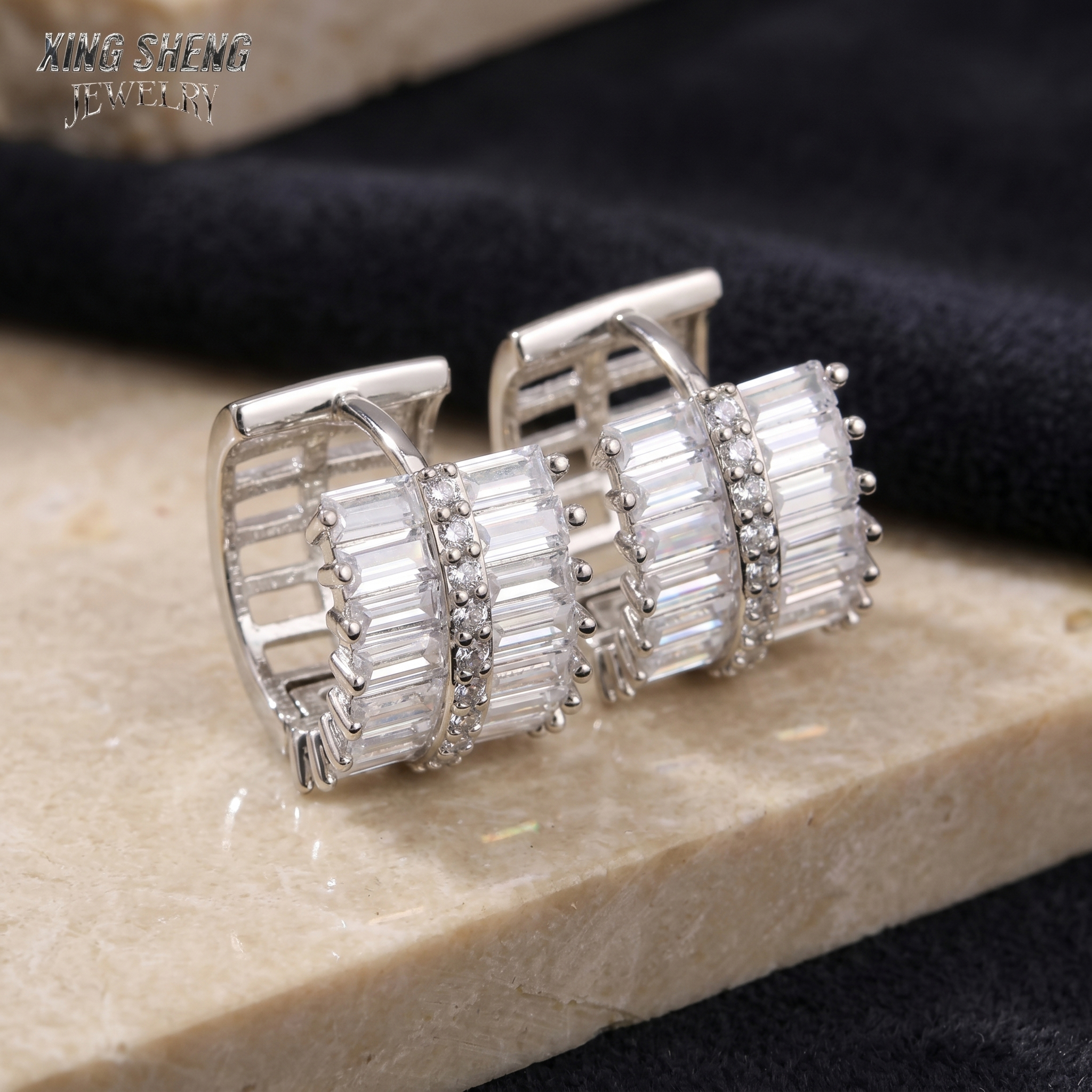 6A quality custom moissanite huggie earrings with alternating baguette and round diamonds, beautifully displayed on a textured stone surface.