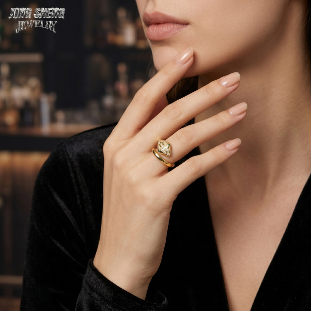 Fashion portrait of a woman in a black velvet dress touching her chin, highlighting the breathtaking sparkle and fire of the 6A VVS moissanite snake ring with a premium finish.