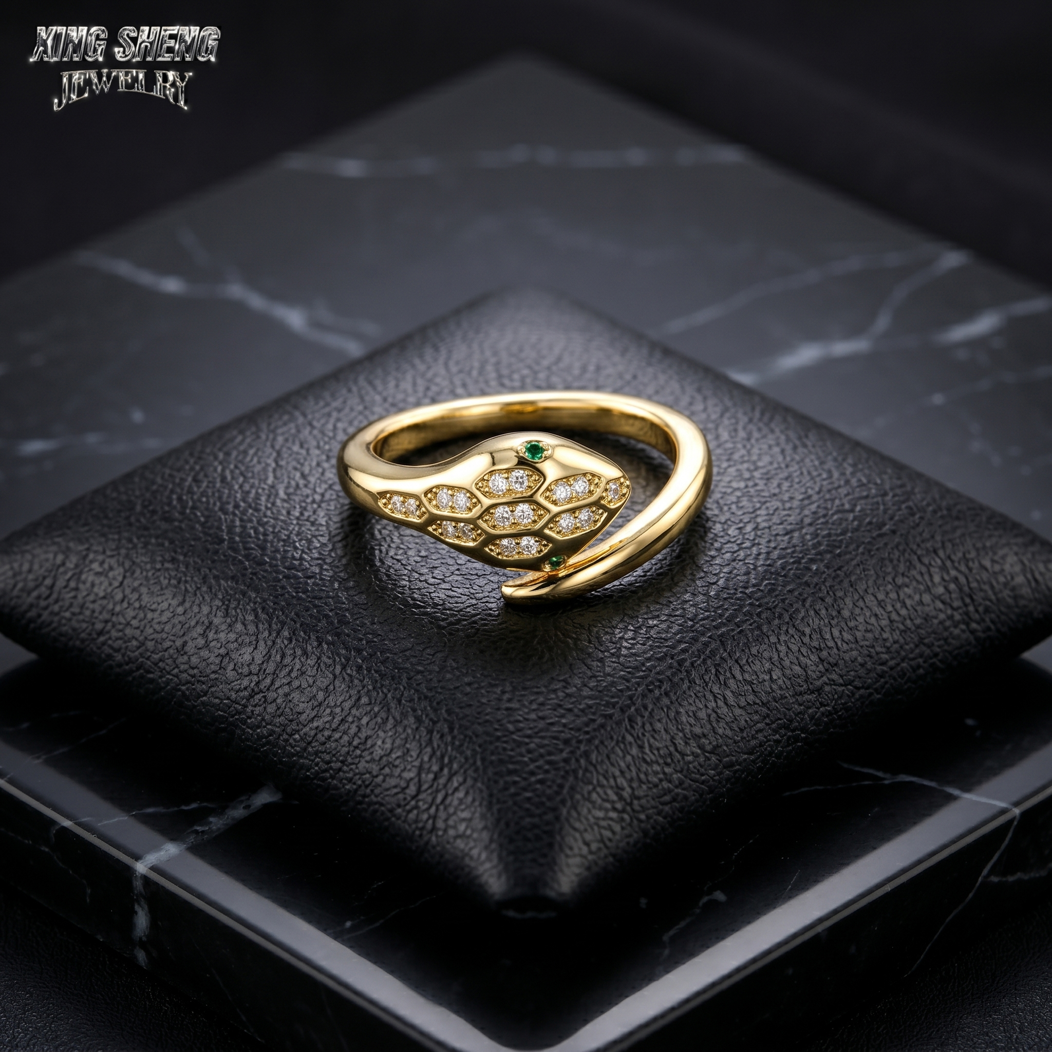 Top-down macro view of the intertwining serpent heads on a black leather cushion, gripping a pristine, colorless round brilliant moissanite with superior light return.