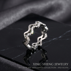 Front view of a brilliant 6A quality round moissanite double layer wavy stacking ring set in rhodium-plated S925 sterling silver, resting on a black marble display.