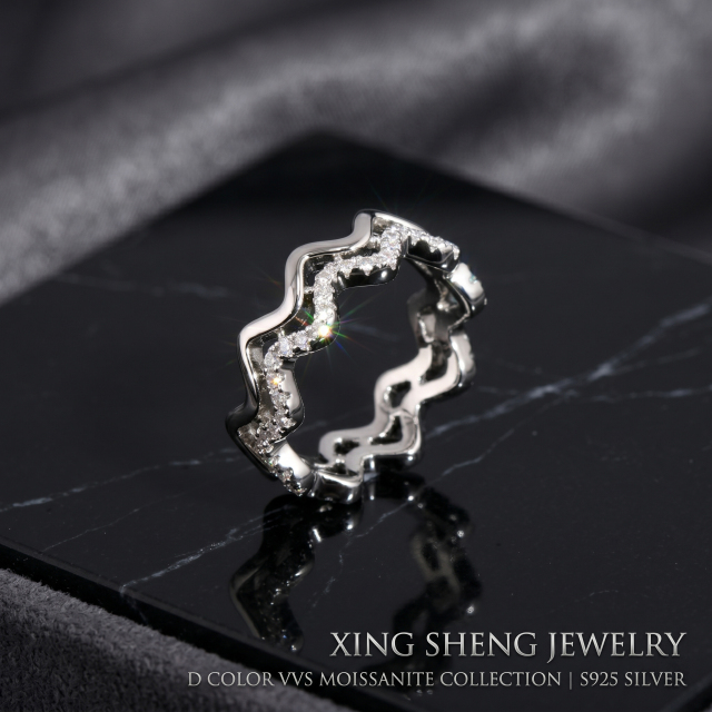 Front view of a brilliant 6A quality round moissanite double layer wavy stacking ring set in rhodium-plated S925 sterling silver, resting on a black marble display.