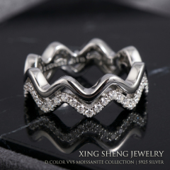 Extreme macro photography detailing the impeccable VVS clarity and fiery brilliance of the top-quality round moissanite stones set in the double layer band.