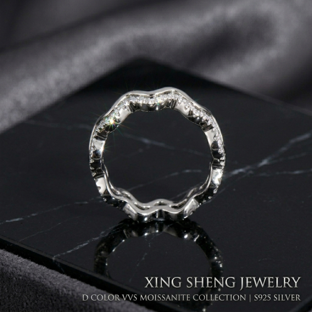 Macro close-up of the Excellent Cut VVS round moissanite stones securely micro-pave set into the flowing wavy band, demonstrating superior rainbow fire and brilliance.