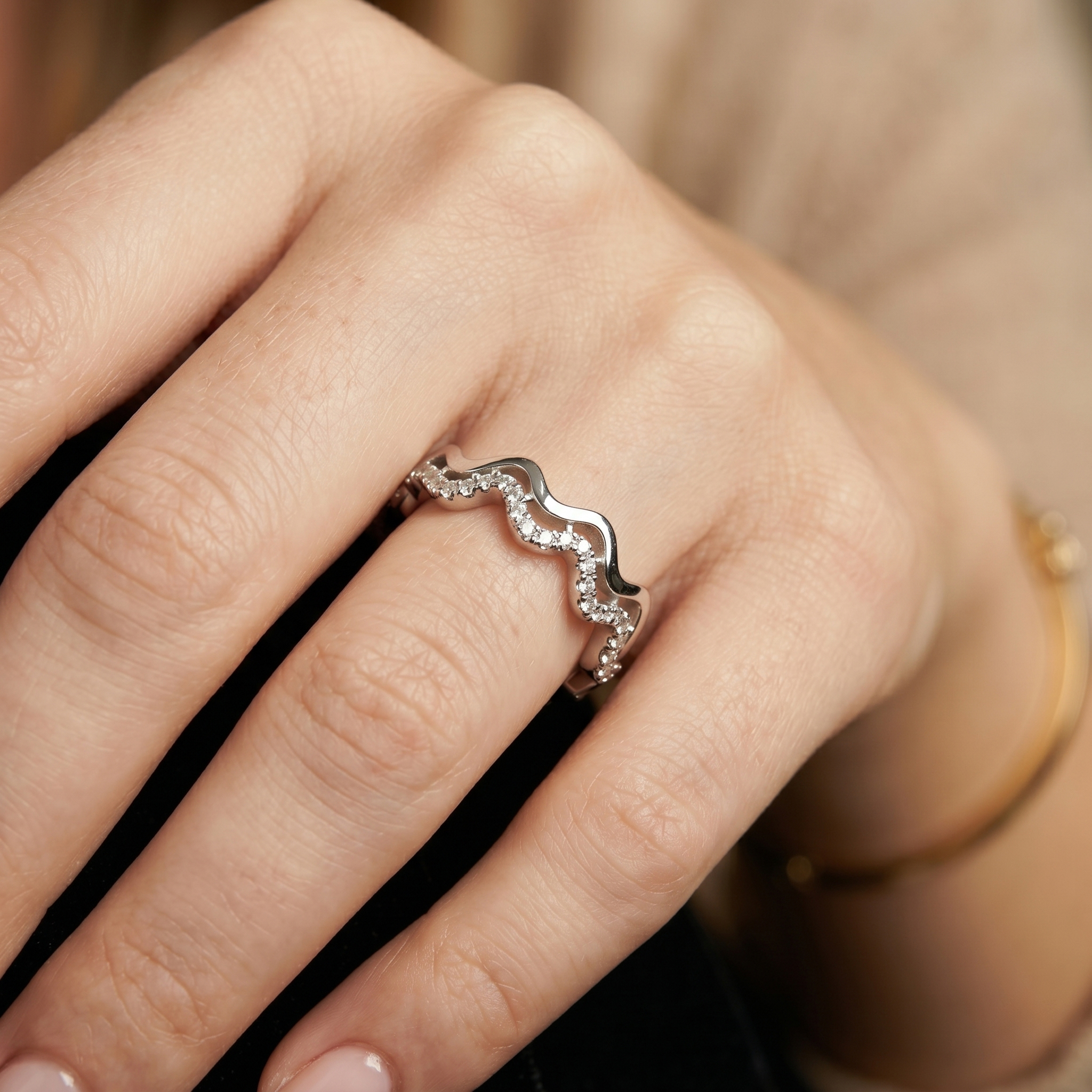Side profile on a model's hand showing the architectural wavy design of the double row moissanite eternity band, a perfect custom anniversary gift.